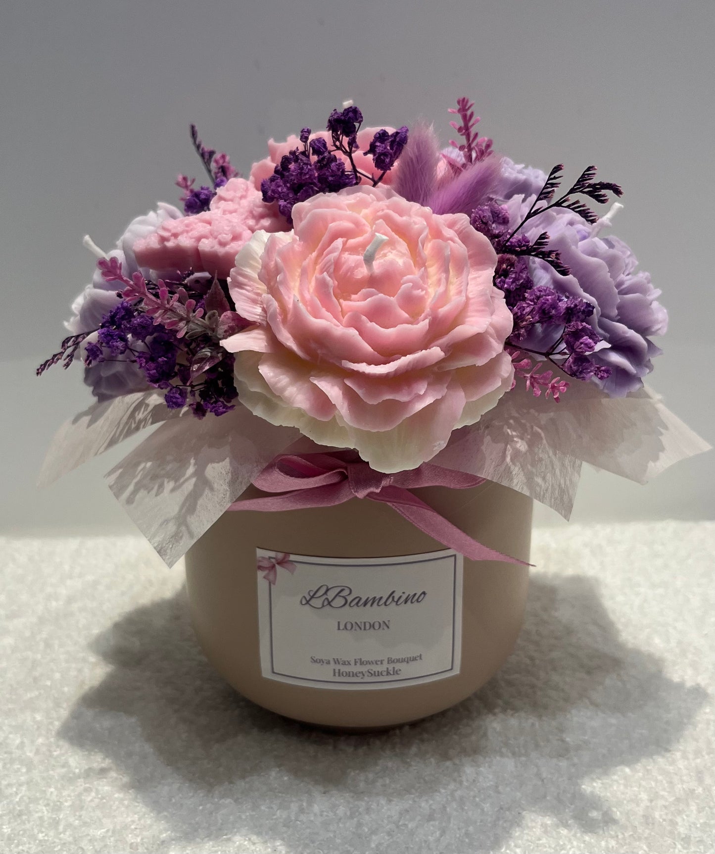 Decorative flower arrangement in a container with a visible brand label on a light background