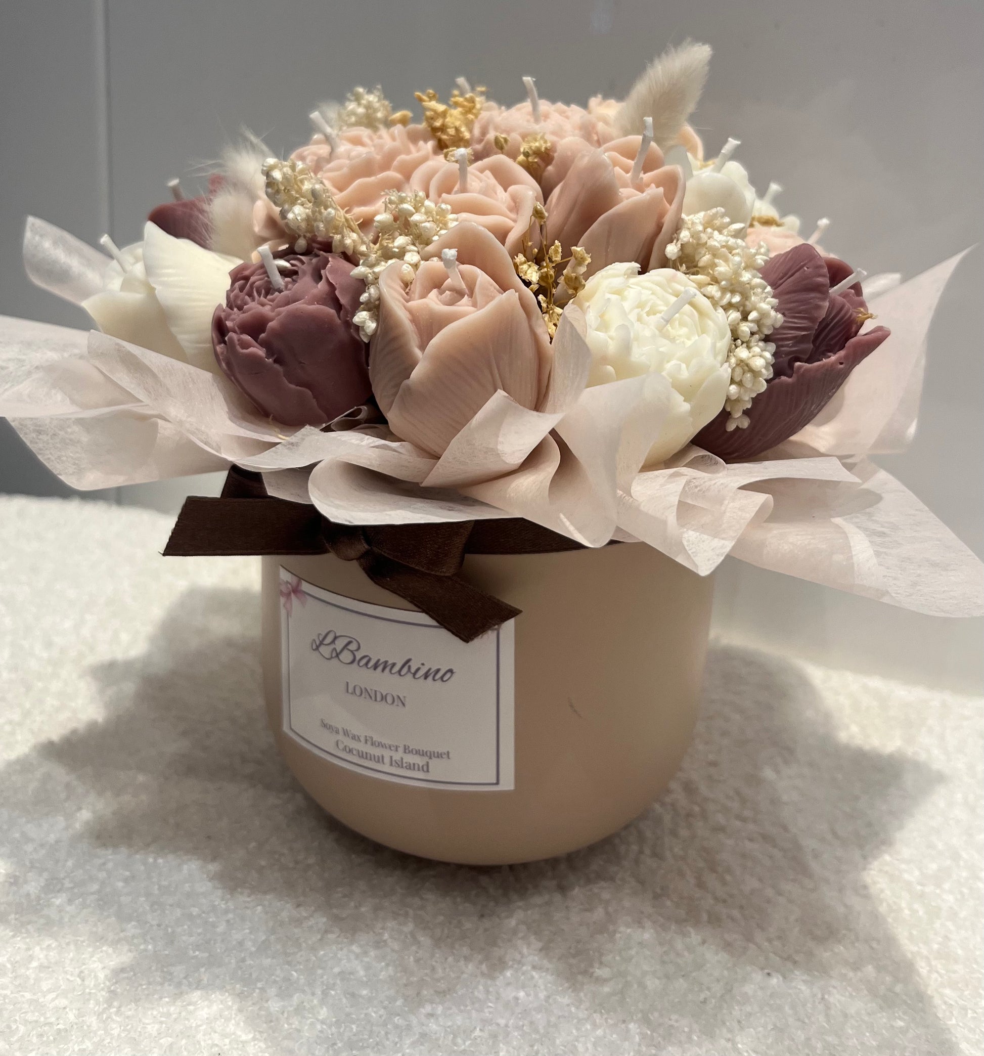 Floral arrangement in a pot with a visible label on a light background