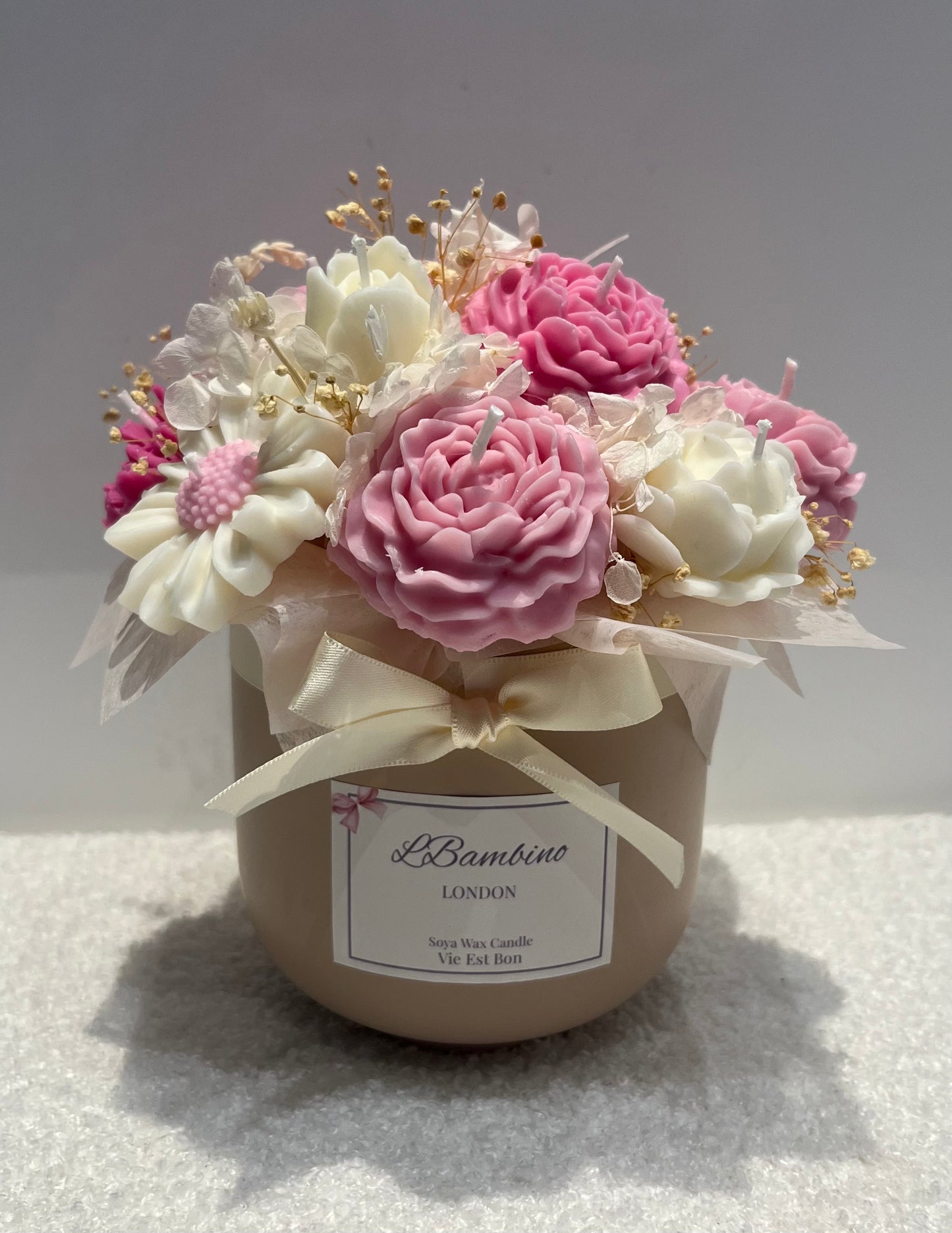 Decorative flower arrangement in a container with a visible brand label on a light background