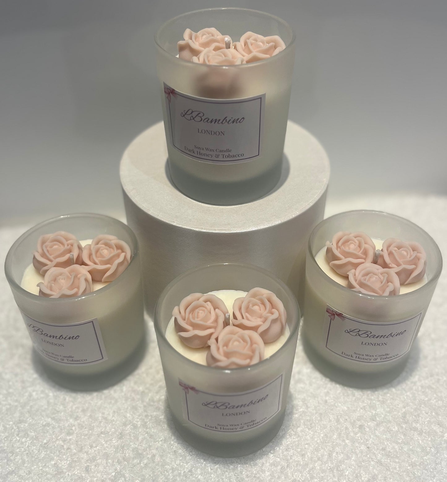 Set of candles with rose decorations on a white surface