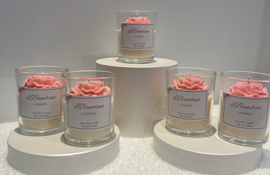 Set of candles with rose decorations and 'L'Bambina' labels on a white background