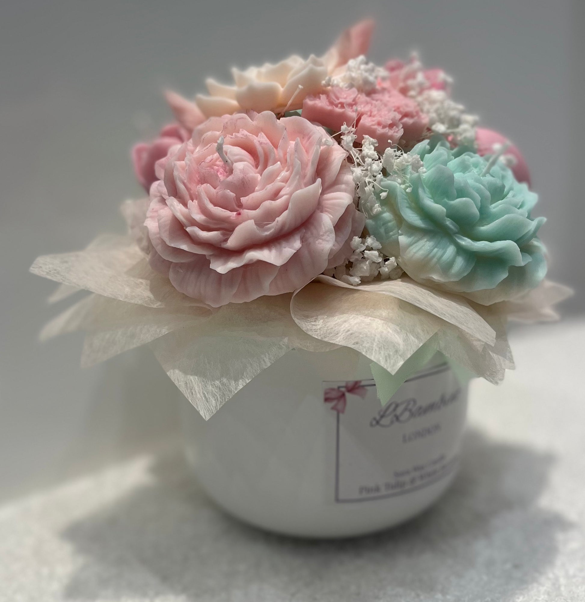 Decorative candle with pink and green flowers on a white background
